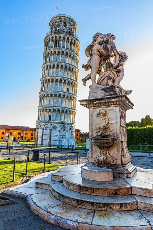 Statue with angels, behind the Leaning Tower, in the morning light, Pisa, Tuscany, Italy