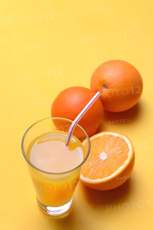 Orange juice in glass and oranges