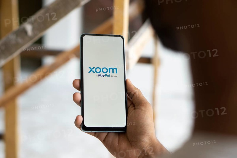 xoom logo is displayed on smartphone. Xoom Corporation is an electronic funds transfer and remittance provider