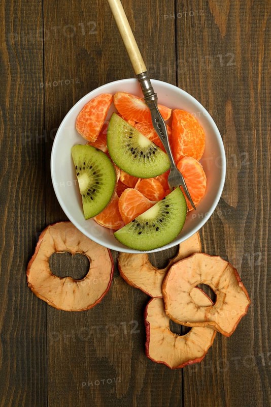 Clementine pieces and kiwi slices in peel, dried apple slices