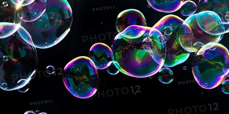 Iridescent soap bubbles in the colours of the rainbow against a black background, Recklinghausen, North Rhine-Westphalia, Germany
