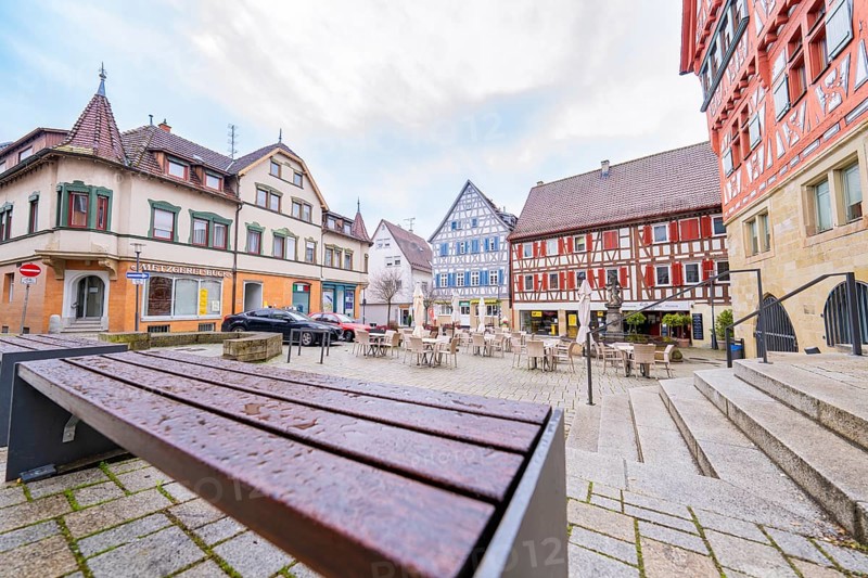Historic square with colourful half-timbered houses and empty benches, Großbottwar, Ludwigsburg district, Baden-Württemberg, Germany