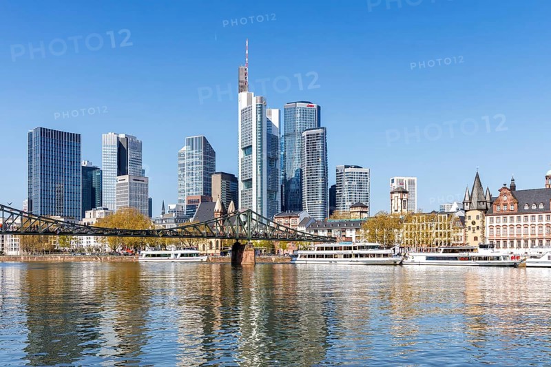 Frankfurt skyline skyscrapers with banks on the river Main with excursion boats and Eiserner Steg in Frankfurt, Germany