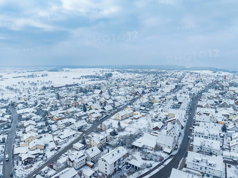 Overview of snow-covered town under cloudy sky, Deckenpfronn, Böblingen district, Germany