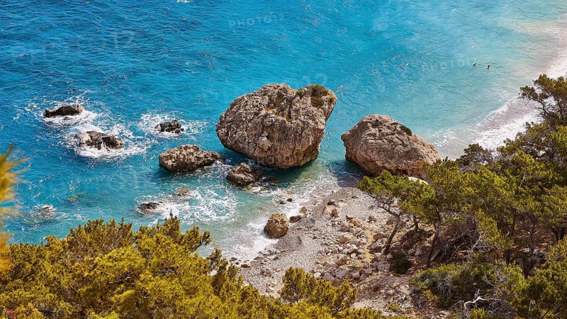Large rocks in the turquoise sea on a coast overgrown with pine trees, Kato Lakkos Beach, still almost unspoilt bay, not accessible by car, Kato Lakkos, east coast, Karpathos, Dodecanese, Greek Islands, Greece