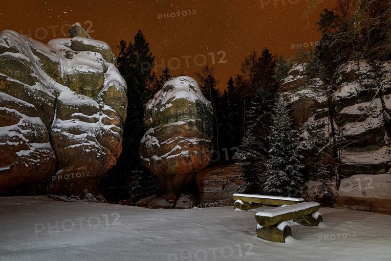 Snow-covered natural monument Kelchsteine at night and snowfall, Oybin, Zittau Mountains, Saxony, Germany