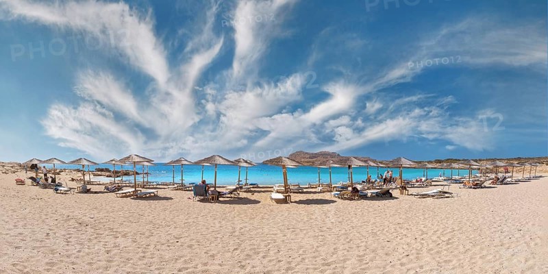 Diakoftis extensive sandy beach with parasols and sun loungers under a clear blue sky, Diakoftis beach, Karpathos, Greece