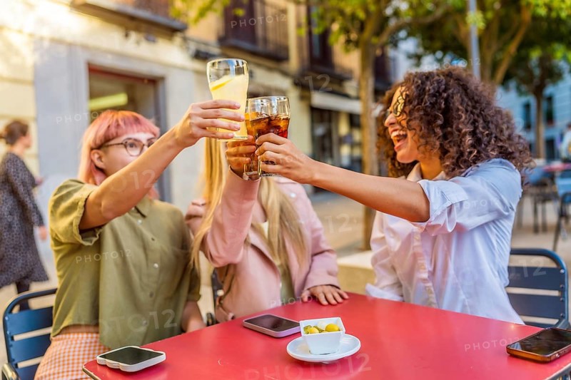 Happy three happy deverse woman toasting in an outdoor bar