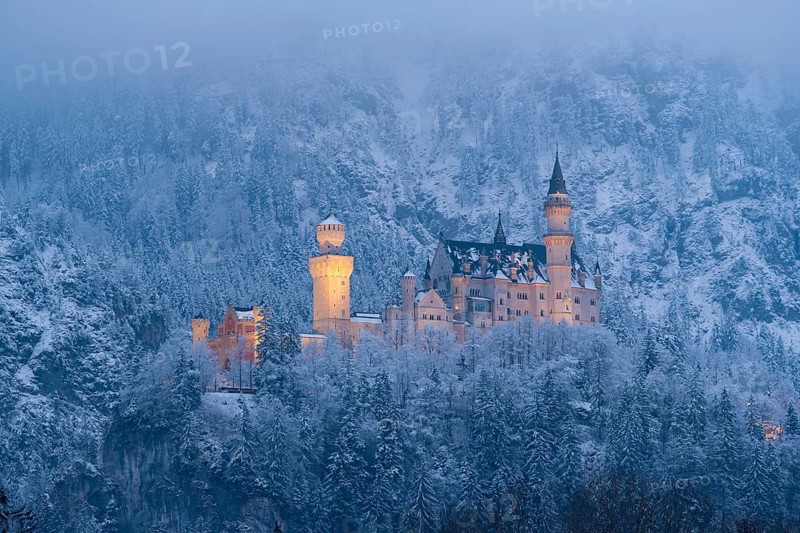 A fabulously illuminated castle in the misty winter landscape at night, Neuschwanstein, Schwangau, Ostallgäu, Allgäu, Swabia, Upper Bavaria, Bavaria, Germany