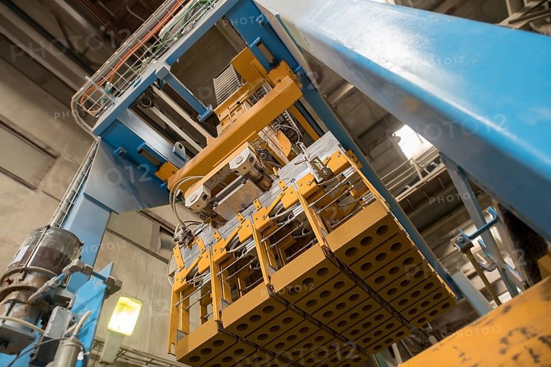 Brickyard. Bottom view of production machine with bricks