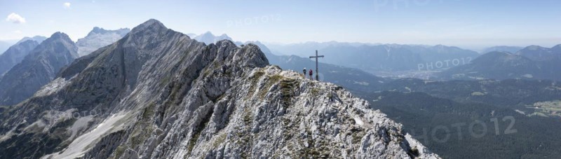 Aerial view, Alpine panorama, hikers at the summit cross, Westliche Wettersteinspitze, Wetterstein Mountains, Bavaria, Germany