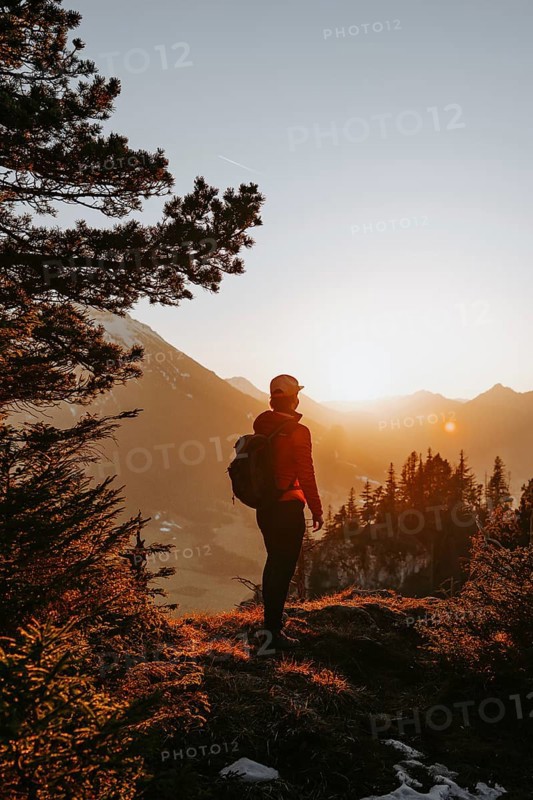 Hiker in the Allgäu at sunset in spring on the Zirmgrat near Pronten in the Allgäu