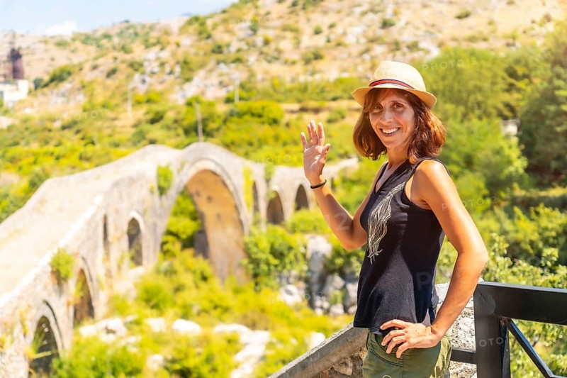 A tourist woman with a hat on the Ottoman Old Mes bridge near Shkoder. Albania, Europe. Ura e Kadiut