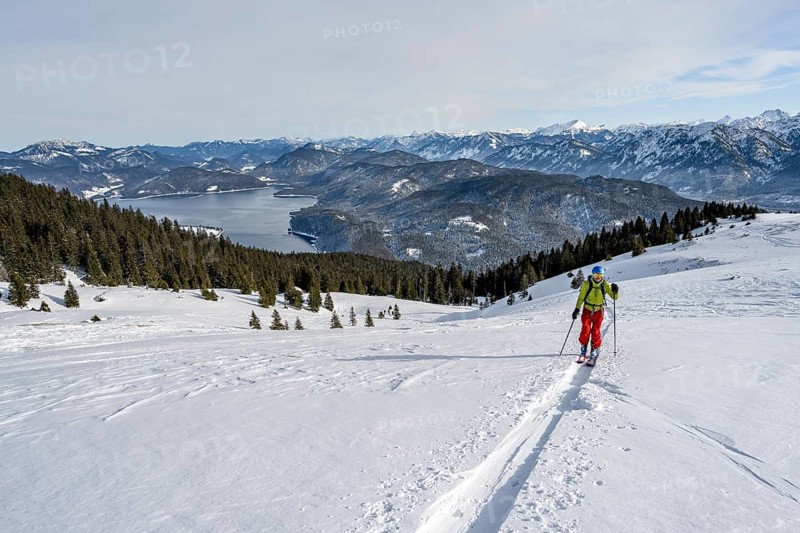 Ski tourers ascending Simetsberg, view of Walchensee and mountain panorama, Estergebirge, Bavarian Prealps, Bavaria Germany