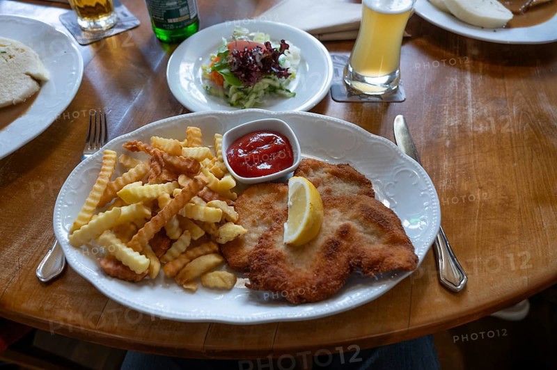Wiener Schnitzel with French fries and salad, served in a pub, Bavaria, Germany