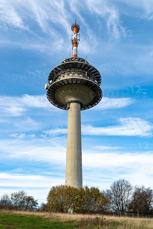 The telecommunications tower on the Köterberg rises into a blue sky with scattered clouds, surrounded by grassy fields and trees, Lügde, Teutoburg Forest, North Rhine-Westphalia, Germany