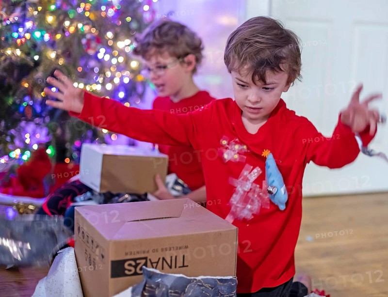 Denver, Colorado - Hendrix Hjermstad, 6, (right) and his brother Adam Hjermstad Jr., 10, open Christmas presents on Christmas morning
