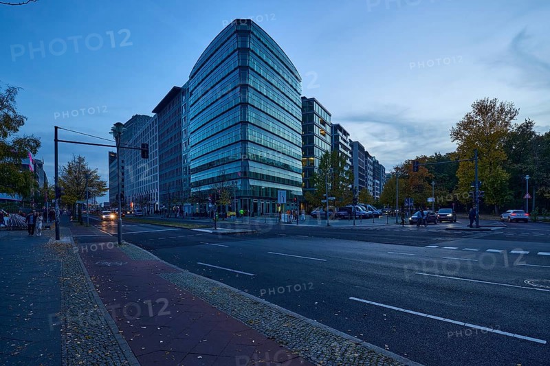 Junction of Lennéstraße with Ebertstraße and glass facade of a commercial building at blue hour in Berlin, capital city, independent city, federal state Berlin, Germany