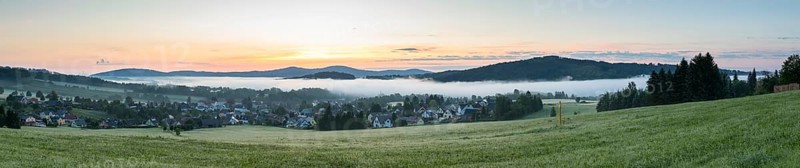 Panorama of the village view with the church of St. Mary's Assumption in the morning fog in front of sunrise, in the background the village church of Crostau, Schirgiswalde, Oberlausitzer Bergland, Saxony, Germany