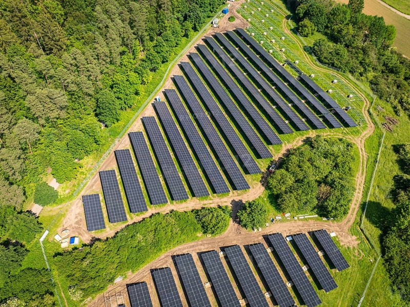 Aerial view of solar panels on an area at the edge of a forest, construction of the Black Forest Nature solar park, Weil der Stadt, Germany