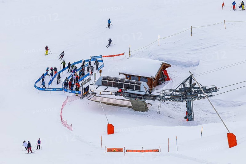 Skiers at the valley station of the chairlift to the summit of Corne de Sorebois, Val d'Anniviers, Valais Alps, Canton Valais, Switzerland