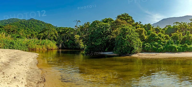 River through the rainforest flowing into Castelhaos beach on Ilhabela island in Sao Paulo, Brazil