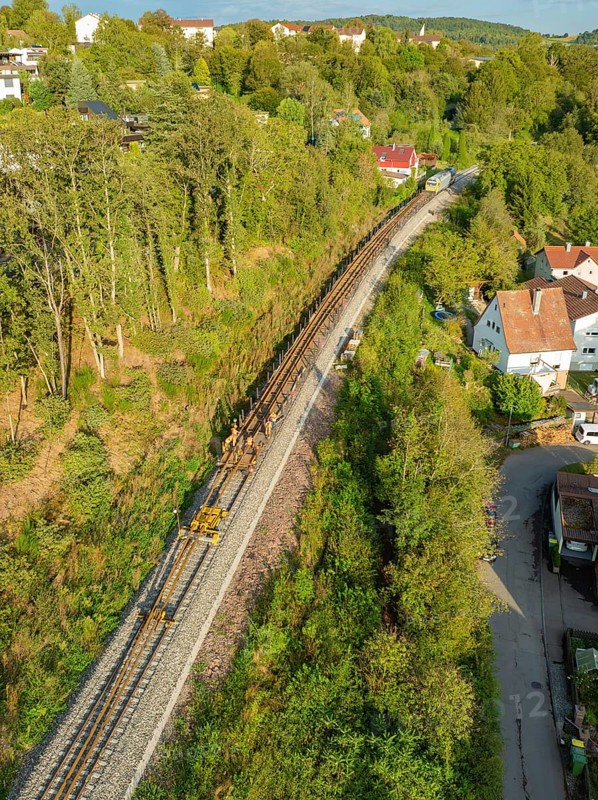 Railway tracks run through a village surrounded by trees, track construction, rail delivery for Hermann Hessebahn, Calw, Black Forest, Germany