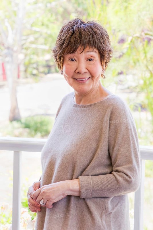 Happy senior chinese woman poses for her portrait outdoors