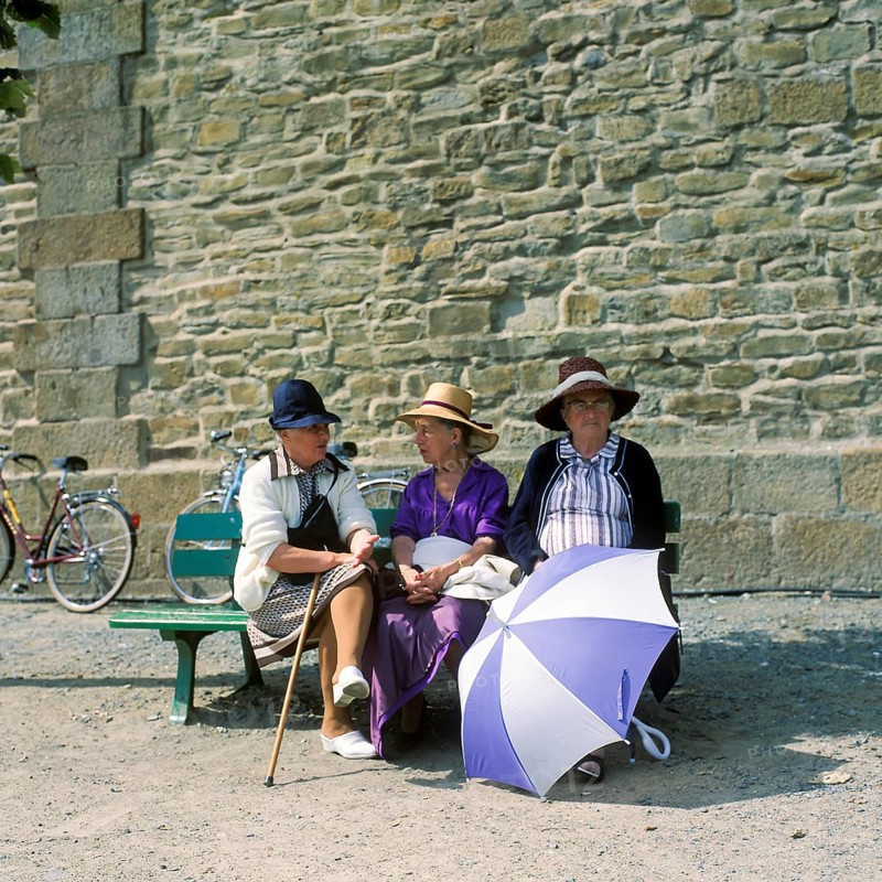 Women on a bench in front of the city wall of St.Malo, Brittany, France