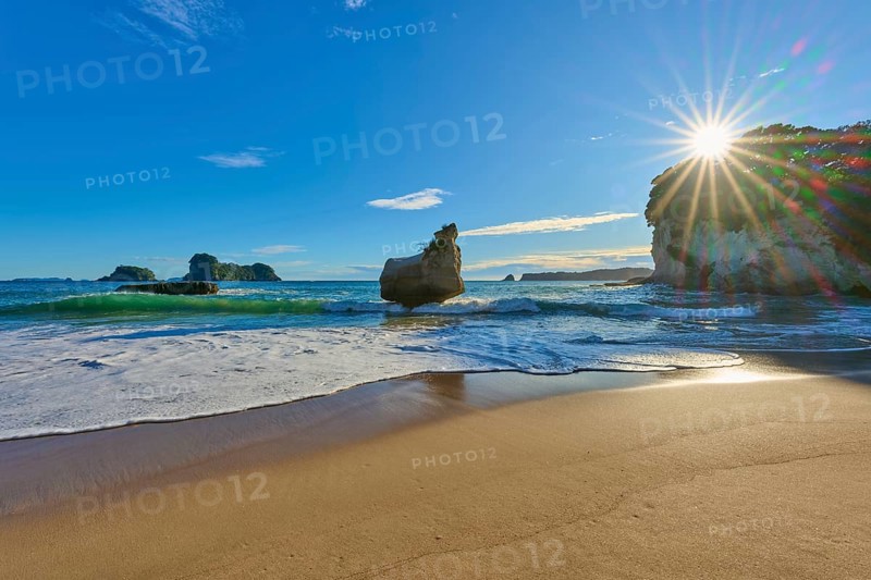 Sunbeams breaking over a rocky beach, Cathedral Cove, Coromandel, Canterbury, North Island, New Zealand