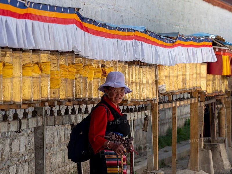 Pilgrims at golden prayer wheels, Xigaze, Tibet, China