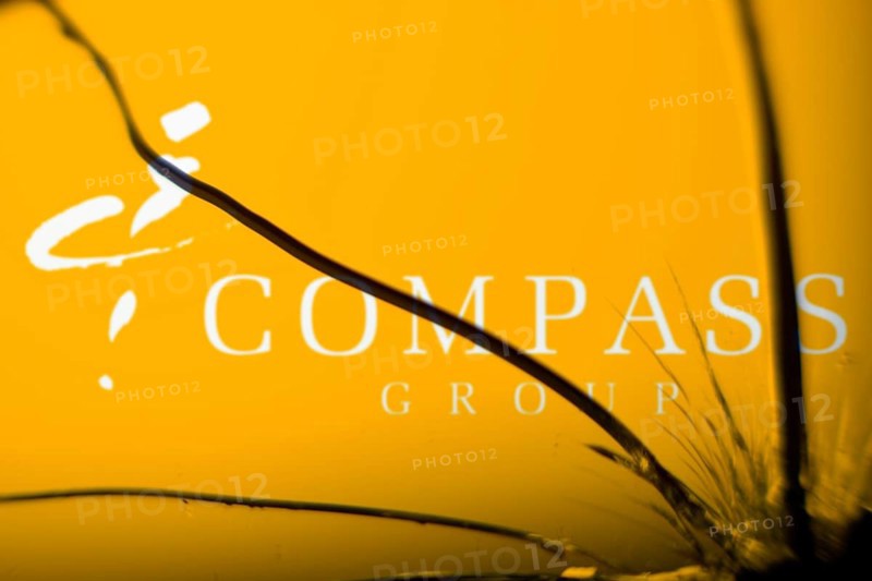Compass Group logo is visible on the broken glass