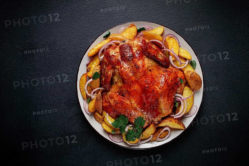 Fried, baked chicken, in the oven, with spices, and rustic potatoes, top view, homemade