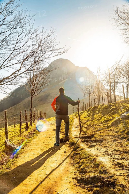 A man climbing Mount Ernio or Hernio in Gipuzkoa at sunset, Basque Country