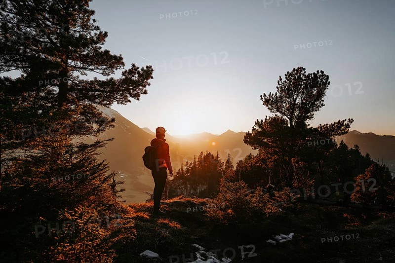 Hiker in the Allgäu at sunset in spring on the Zirmgrat near Pronten in the Allgäu