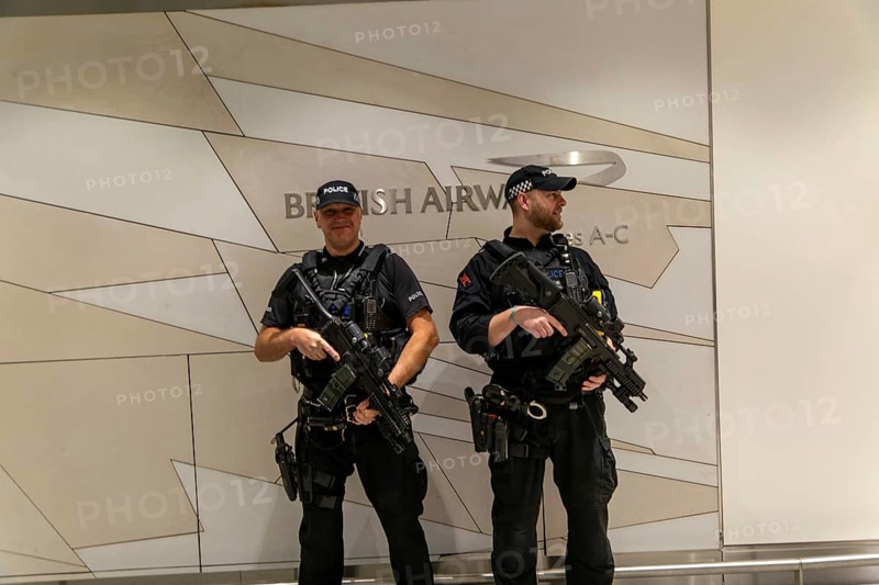 Two armed police officers on duty inside South Terminal, London Gatwick airport, England, UK