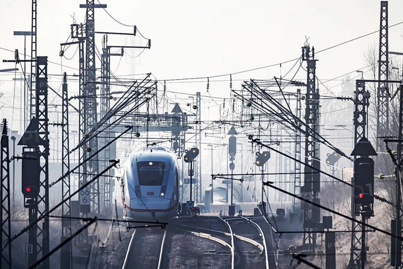 Deutsche Bahn AG tracks with ICE train against the light. Overhead line, signals and infrastructure. Railway tracks at the Geislinger Steige, Alb ascent to the Swabian Alb. Amstetten, Baden-Württemberg, Germany