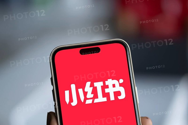RedNote (Xiaohongshu) logo is displayed on iPhone