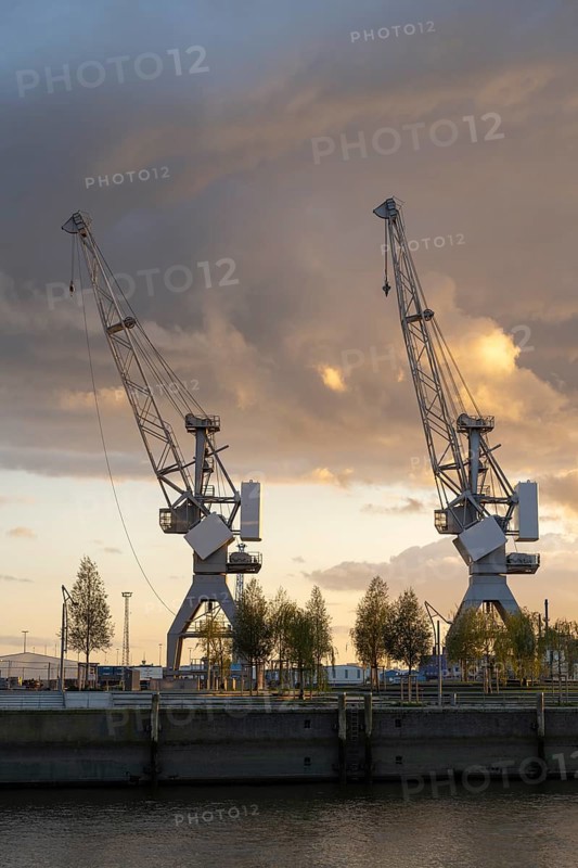 Dramatic clouds over the Strandkai, historic crane, sunset, Überseequartier, Hafencity, Hamburg, Germany