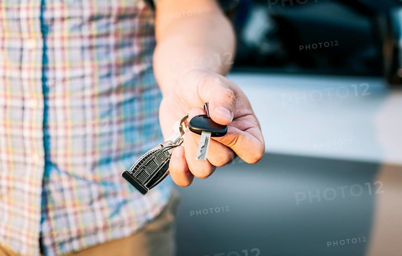 Driver's hands showing the car keys, Close-up of male driver hands showing the keys, Vehicle rental concept. Close-up of people holding car keys