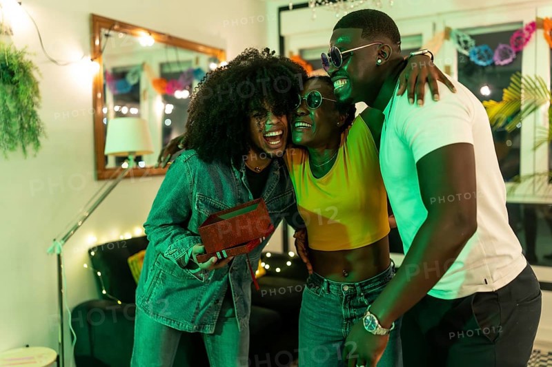 African young woman hugs her friends gratefully for a birthday gift at home