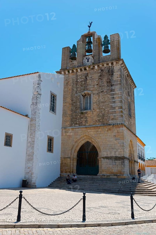 Historic church with bell tower, surrounded by white buildings, under a bright blue sky, Sé Catedral de Faro, Cathedral of Faro, Largo da Sé, Faro, Algarve, Portugal