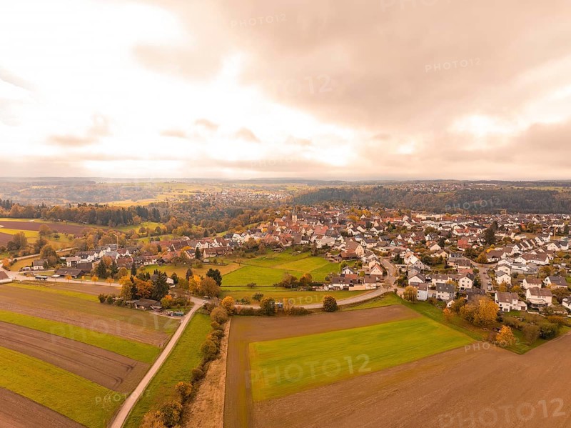 View of a town in an autumnal landscape with clouds in the sky, Tiefenbronn, Germany
