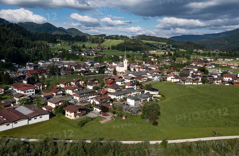 Drone shot, view of the village with parish church, Kössen, Leukental, Tyrol, Austria