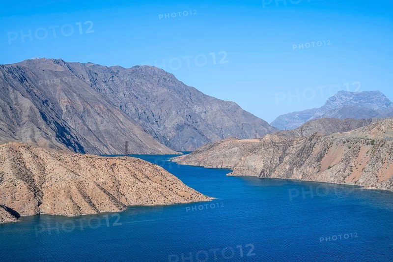 Blue Toktogul reservoir between dry mountain landscape, Jalalabad region, Kyrgyzstan