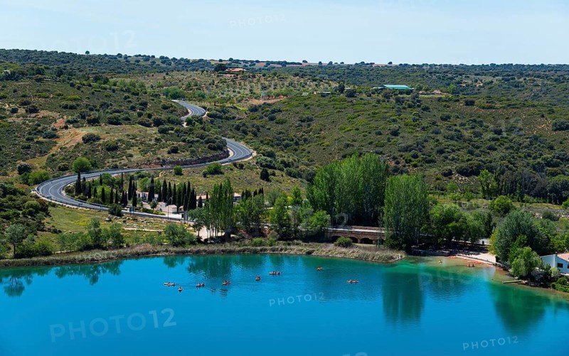 Panorama of a lake with surrounding trees, roads and hills under a clear sky, view from the viewing platform, Mirador de la Laguna del Rey, Lagunas de Ruidera National Park, Albacete province, Castilla-La Mancha, Spain