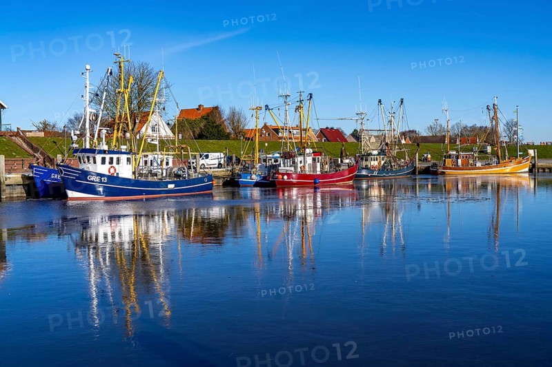 The fishing village of Greetsiel, historic fishing harbour, with the largest shrimp cutter fleet in East Frisia, historic houses, winter, partly frozen, in Lower Saxony, Germany
