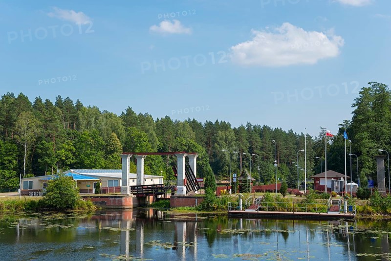Lock with bridge and neighbouring building in forest landscape in sunshine, Sluza Kurzyniec, Sluza, lock, border between Belarus on the left and Poland on the right, Kanal Augustowski, Augustow Canal, Rudawka, Plaska, Plaska, Powiat Augustowski, Podlaskie, Podlaskie, Poland