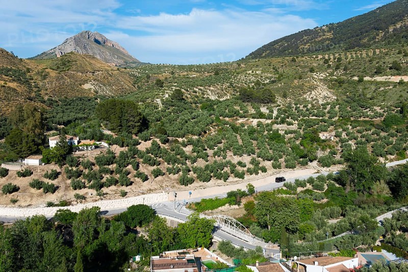 Green hills and a village on a winding road, surrounded by lush natural scenery, near Bedmar y Garcíez, Bedmar y Garciez, Sierra Mágina Natural Park, Jaén province, Jaen, Andalusia, Spain