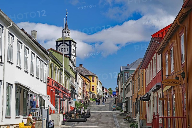 City street with colourful buildings, a striking church and light clouds in the blue sky, Unesco World Heritage Site, miners' town, Röros, Norway